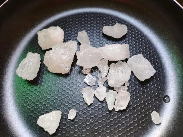 250克的冰糖倒入平底不粘锅里（冰糖敲小一点比较容易化）