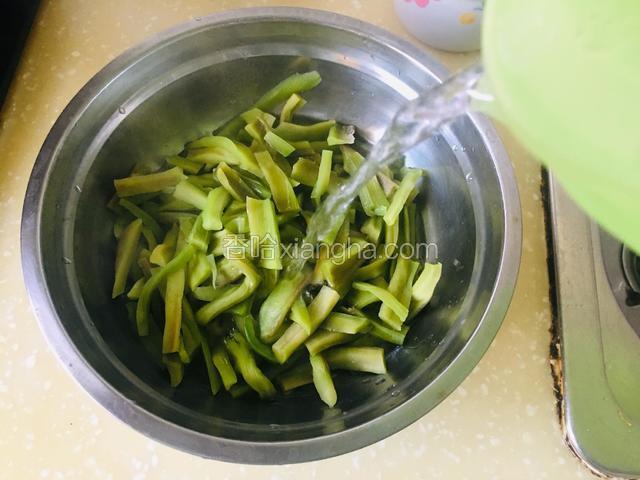 捞出放入盆中，用凉开水冲凉，沥去水份。