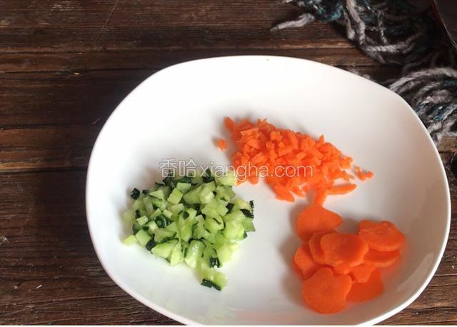 胡萝卜洗净去皮切成薄片，用小兔子模具压出小兔子模样，黄瓜洗净切小粒