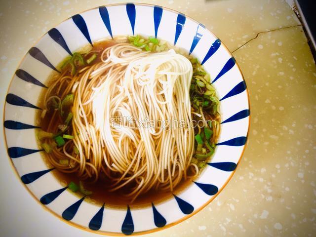 将煮熟的龙须面挑入碗中。