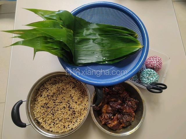 包粽子: 准备好新鲜采摘处理好的粽叶，腌制好的酱香排骨，棉线，剪刀，牙签一根，泡好的糯米。