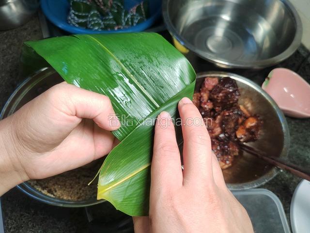 一片粽叶，折叠一个三角形。