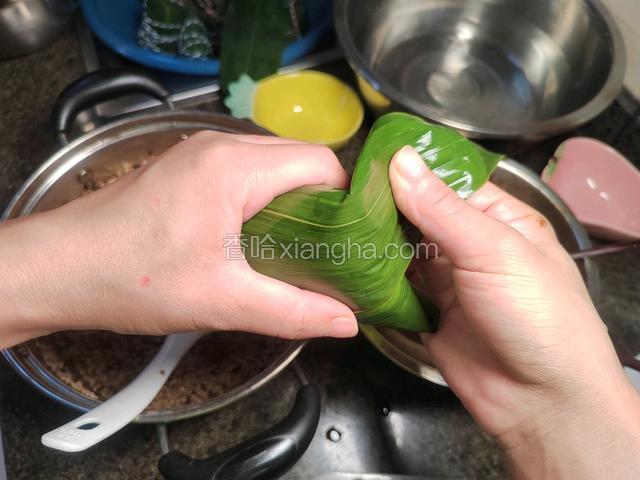 折叠多余的粽叶。