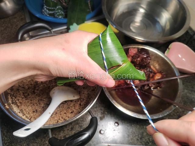 左手无名指把绳子捏住固定，右手绕线。