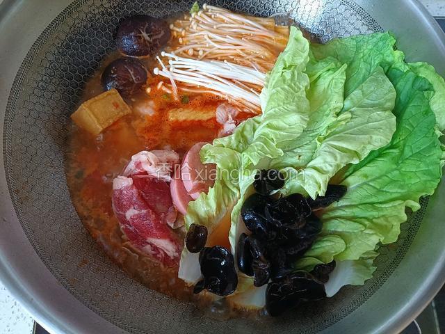 水开先放火锅丸子、火腿肠和金针菇、香菇，再放羊肉木耳和小白菜