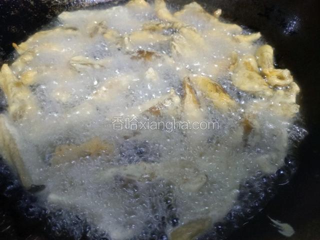 锅里加入多一点的植物油，中火烧至六成热，一根一根下入蘑菇，待蘑菇定型后，用漏勺翻动，受热均匀。