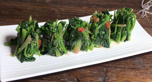 再用锋利的菜刀，将菠菜条切成小段，竖着摆入盘中