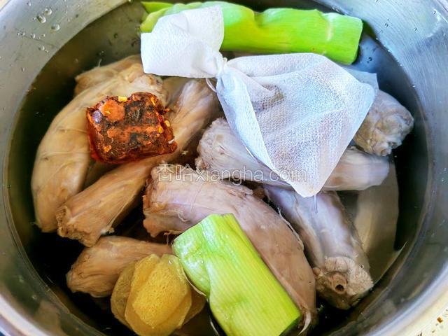 鸭脖放入汤锅，加葱姜、火锅底料、卤肉料包