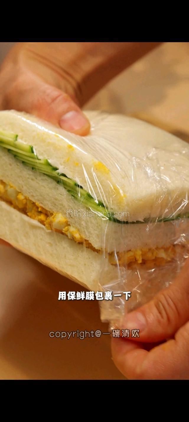 将包好的三明治用保鲜膜包裹一下。