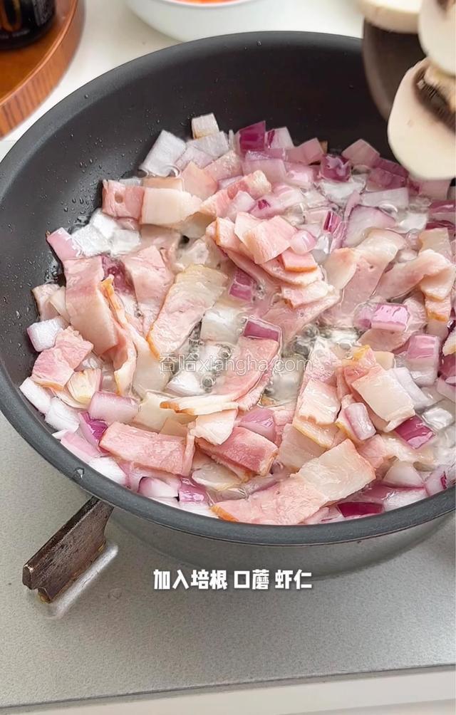 锅热油放入洋䓤炒香，加入培根囗蘑虾仁，炒熟盛出备用