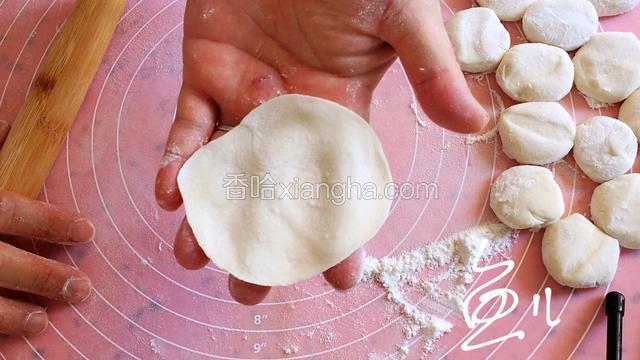 将小剂子压扁，擀成中间厚边缘薄的面皮