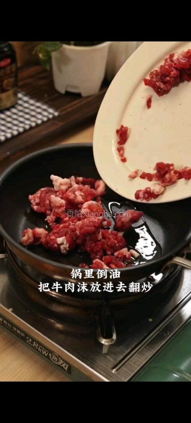锅里倒油,放牛肉沫放进去翻炒。倒入切好的配菜。