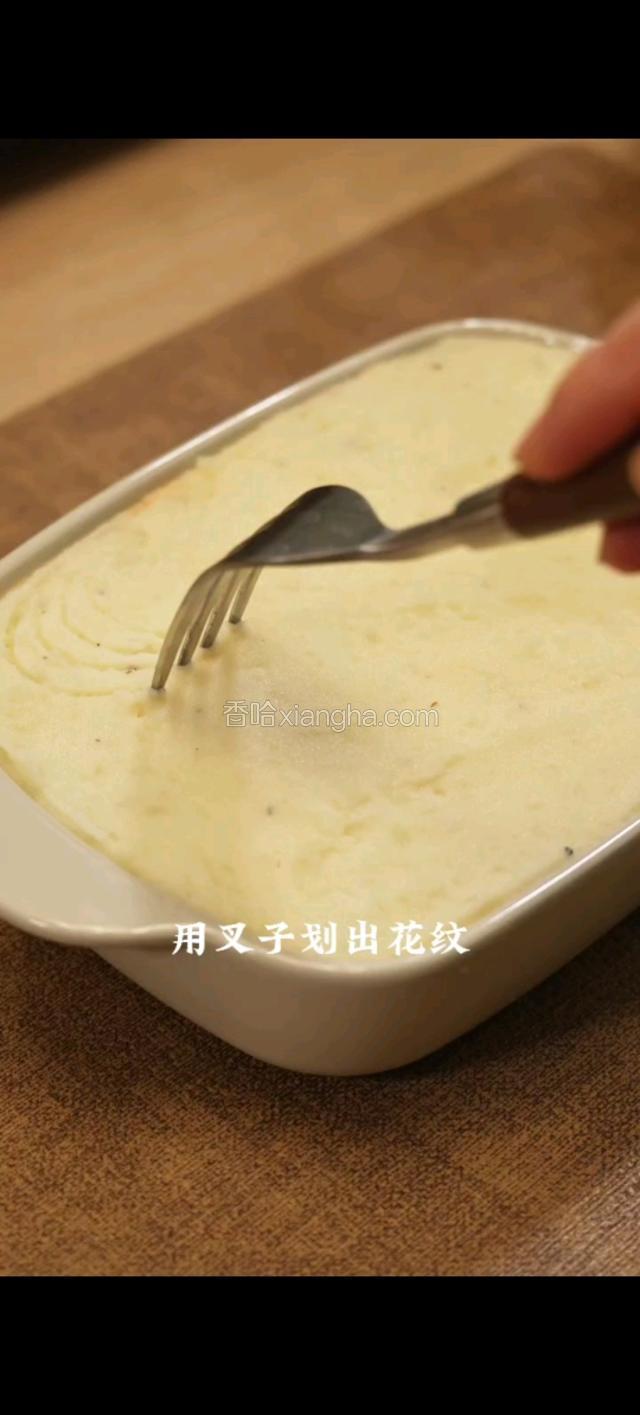 用叉子划出花纹。上面撒满干酪，放入烤箱。