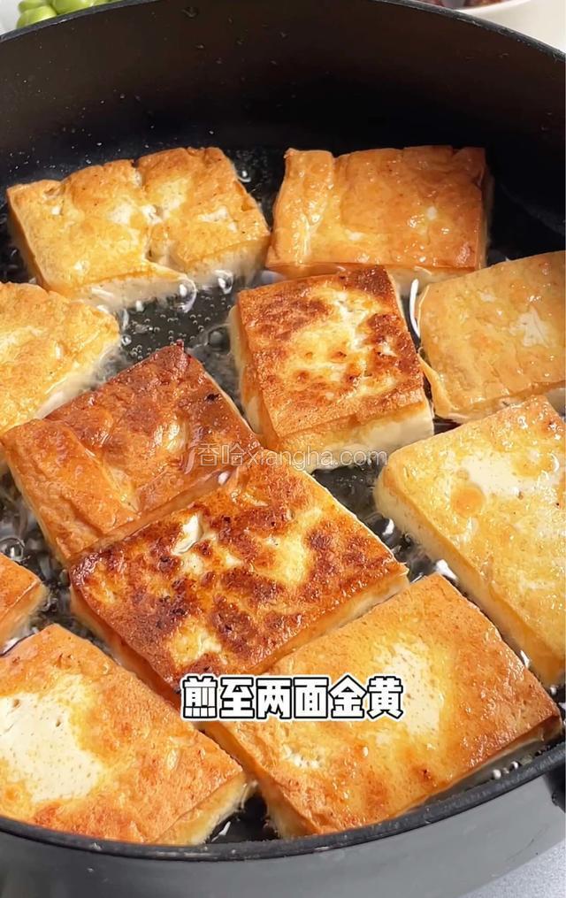 油热放豆腐,煎至两面金黄