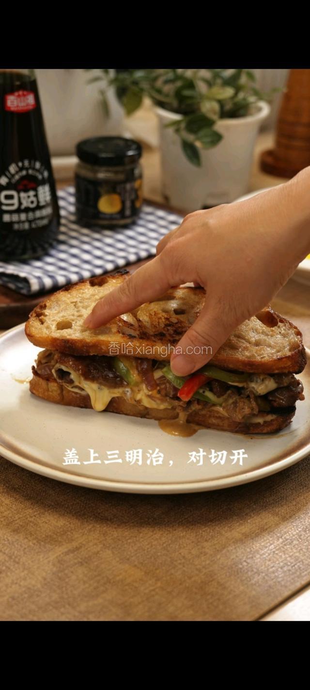 将芝士牛肉盖上三明治对半切开。