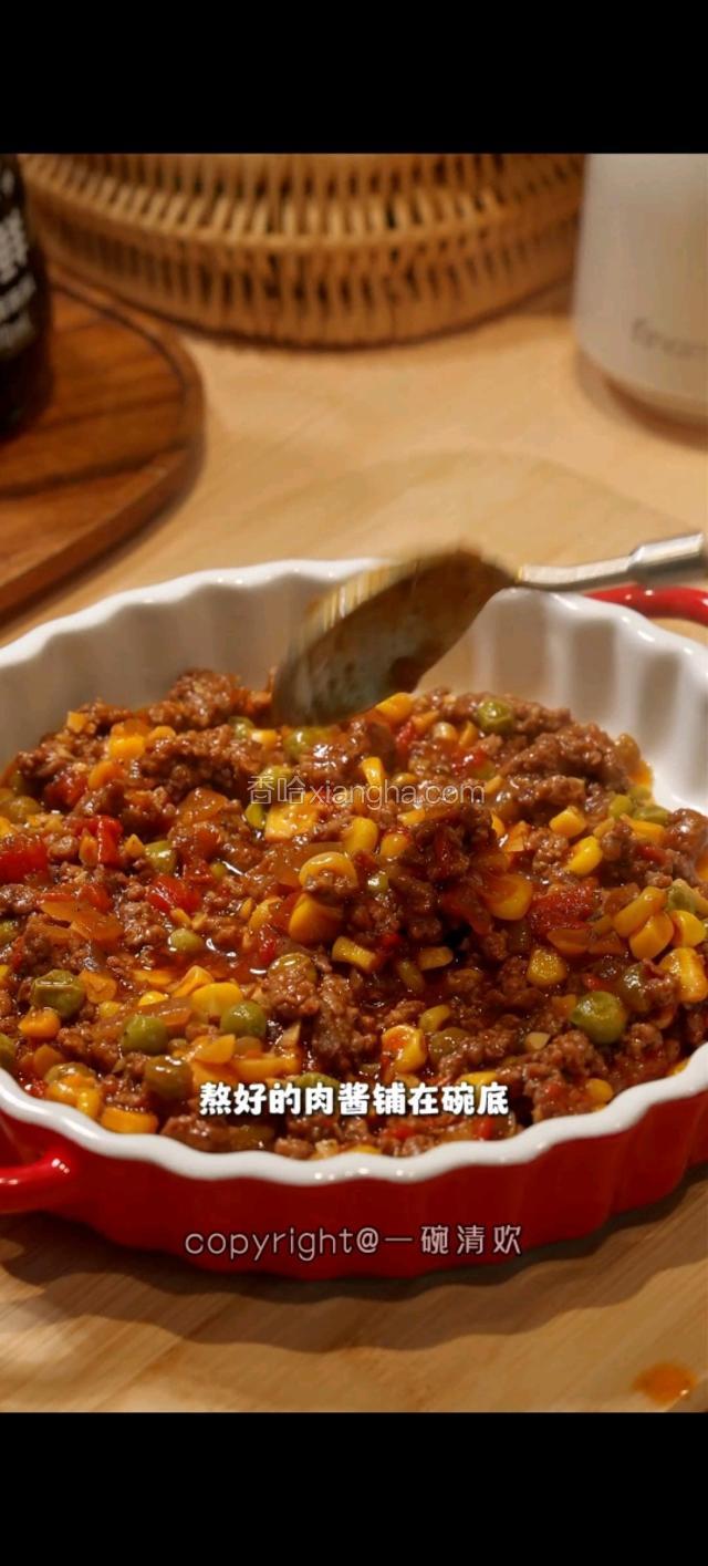 熬好的肉酱铺在碗底。上面盖一层土豆泥。用叉子做一个花纹。