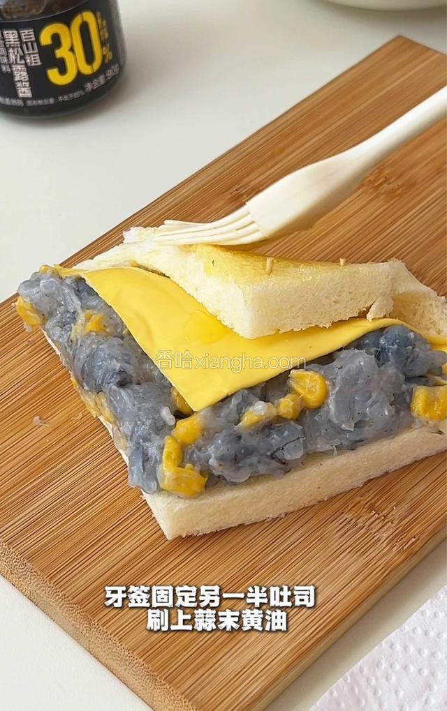 牙签固定另一半吐司，刷上蒜未黄油