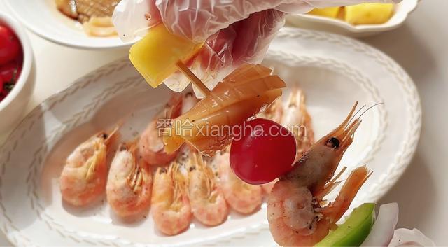 将处理好的食材和加拿大北极虾依次穿到竹签上。