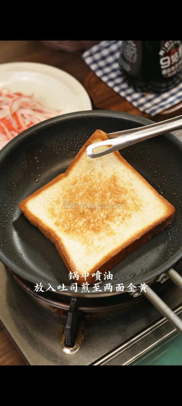 锅中喷油放入吐司煎至两面金黄