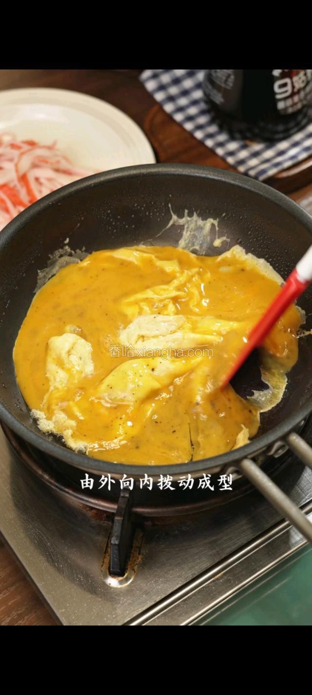 倒入鸡蛋，由外向内拨动成型