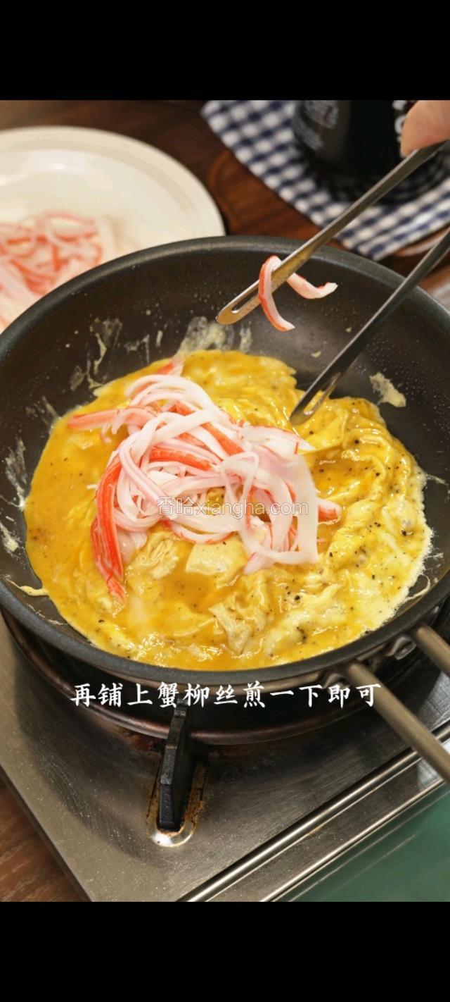 再铺上蟹柳丝煎一下