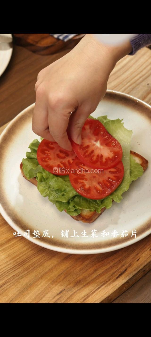 吐司垫底，铺上生菜和番茄片
