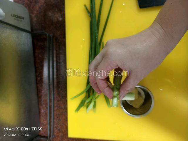 这期间把葱白切几段，葱叶切葱花，并将小块姜去加切块。把葱白和生姜块放入滤网并投入砂锅中。